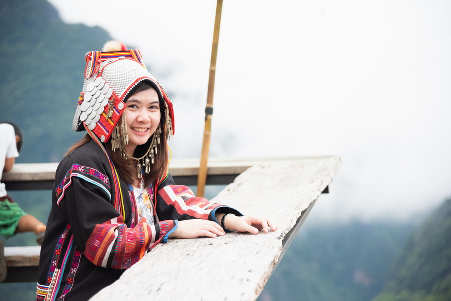 chica sonriente usando gorro tejido y un cardigan con elementos de colores